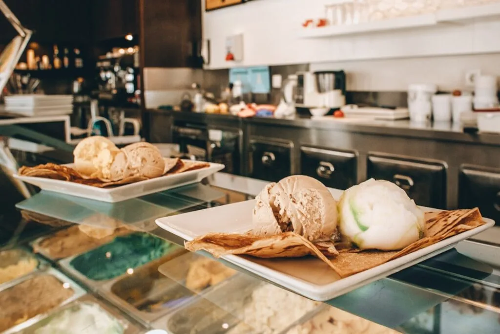 Scoops of ice cream served on crepes at a café counter
