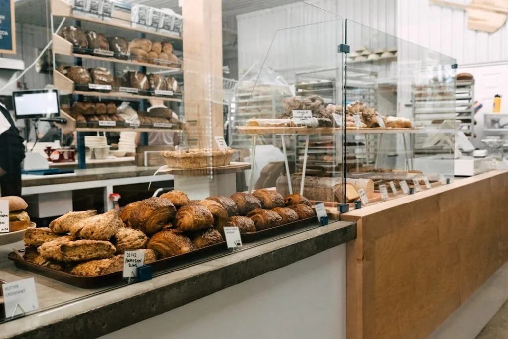 Bakery counter displaying croissants and breads behind glass shelves