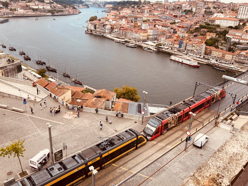 Two trams passing along the Douro riverfront in Porto's Ribeira