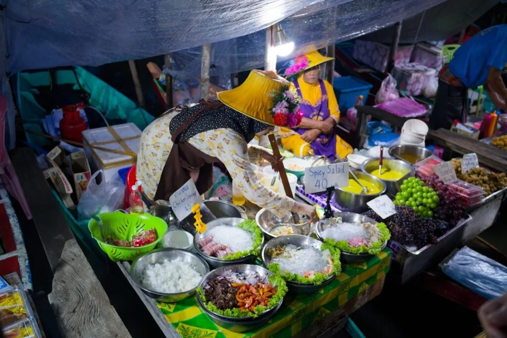 Vibrant street food stall with a vendor serving bowls at a night market