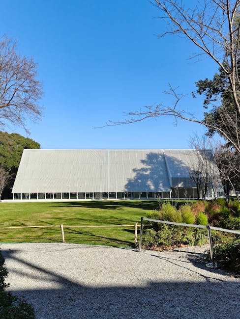 Long white pavilion with sloping roof on a grassy park lawn in Porto