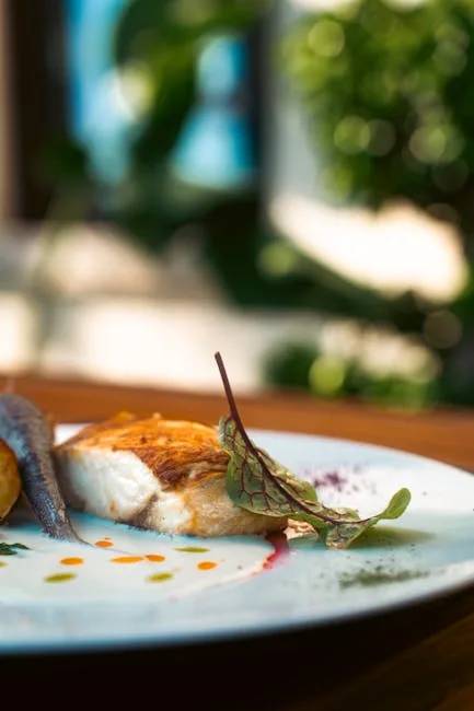 Seared fish fillet with microgreen garnish on a restaurant plate in Porto.
