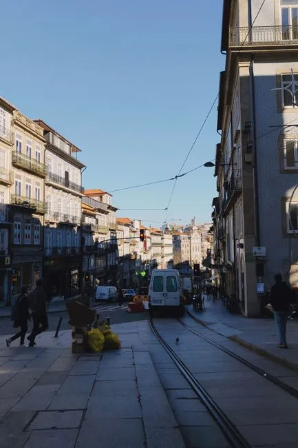 Historic Porto street with tram tracks and buildings under clear sky