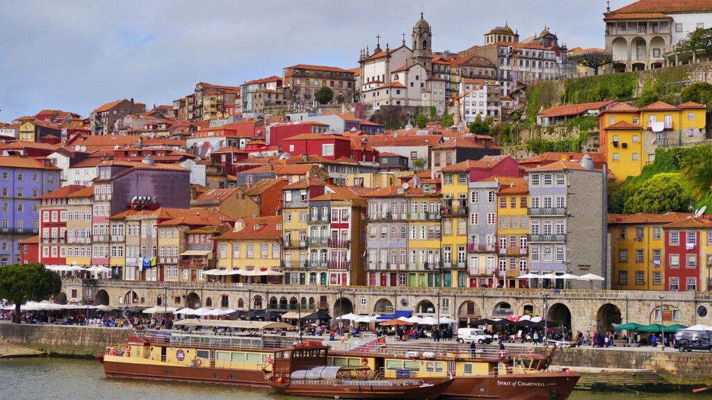 Traditional boats moored by colorful houses on Porto's Douro waterfront