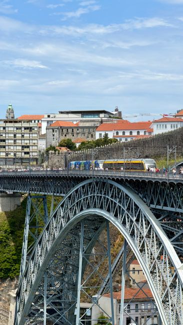 Metal arch of Dom Luís I Bridge with commuter train in Porto