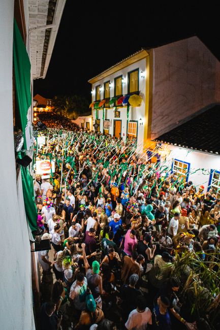 Street festival crowd with streamers filling narrow Porto alley at night