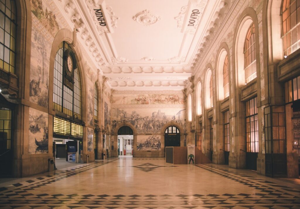 Empty ornate train hall with tiled murals and high windows in Porto