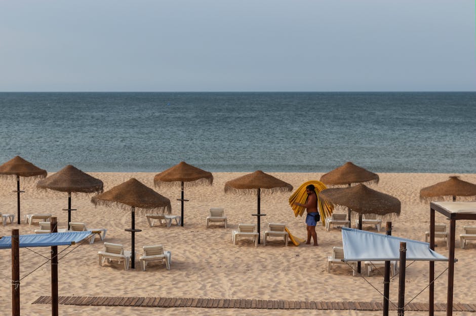 Algarve latem — zatłoczona plaża i parasole