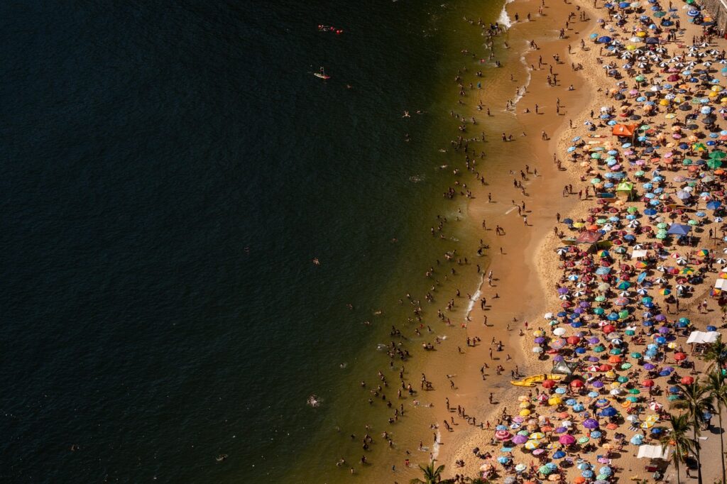 Zatłoczona szeroka piaszczysta plaża Praia da Rocha rano