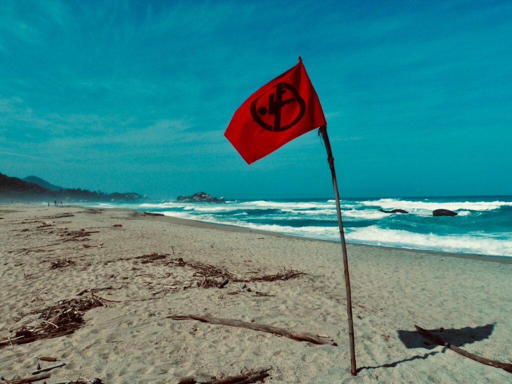 Czerwona flaga ostrzegawcza na plaży Praia da Arrifana