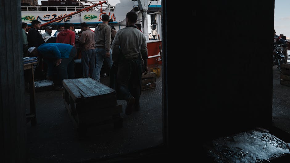 Kleine Gruppe beim Verhandeln an Fischständen auf dem Markt in Olhão am frühen Morgen