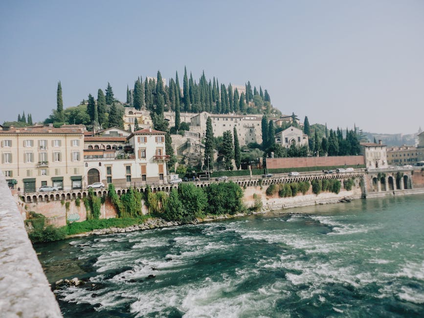 Panorama der Häuser am Ufer des Etsch und bewaldete Hügel von Verona