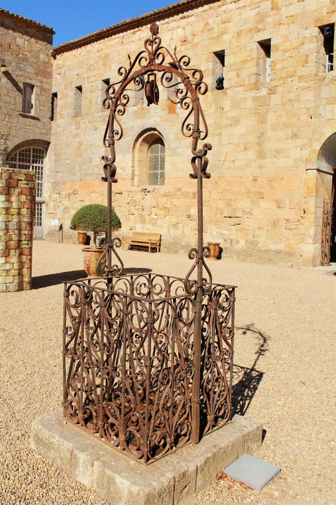 Pozzo in ferro battuto finemente lavorato in cortile di palazzo storico