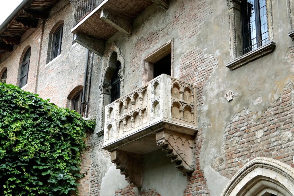 Balcone di Giulietta in pietra sopra muro di mattoni con edera, Verona