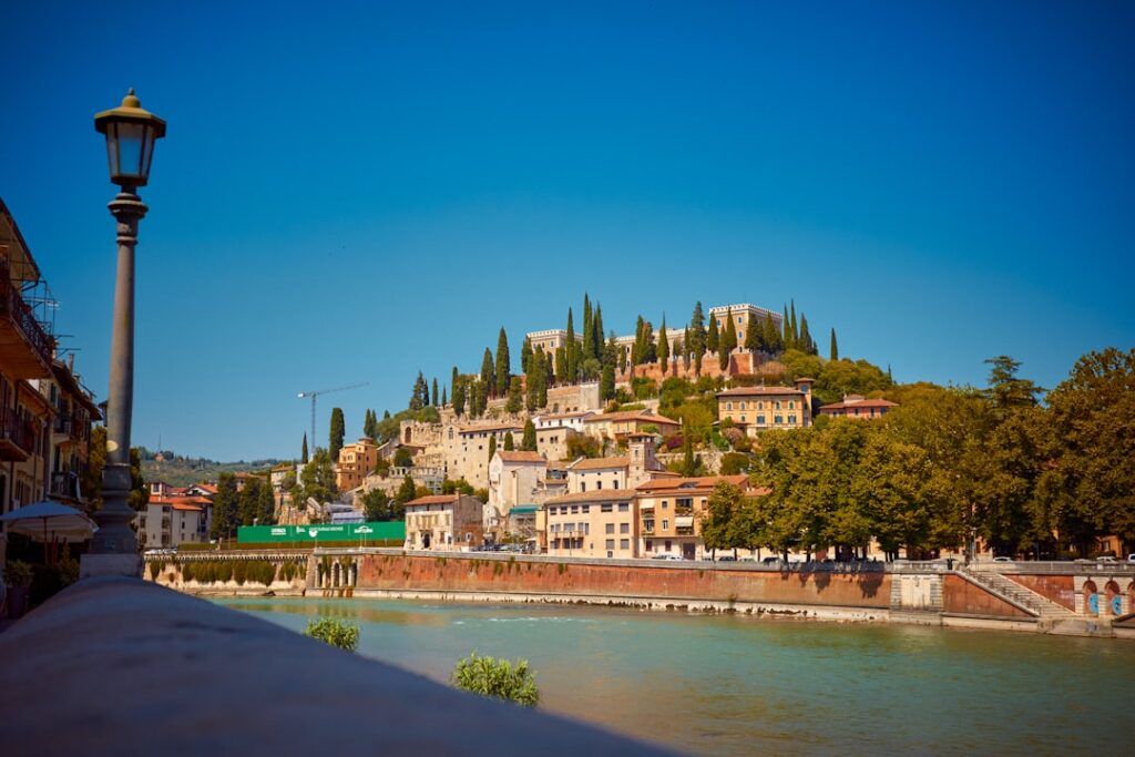 Colle di Castel San Pietro sopra l'Adige con case e cipressi