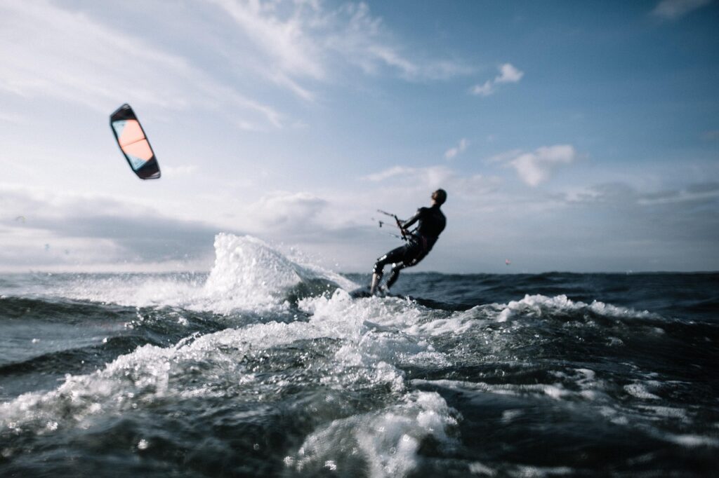 Kitesurfer na falach Jeziora Garda z latawcem nad głową