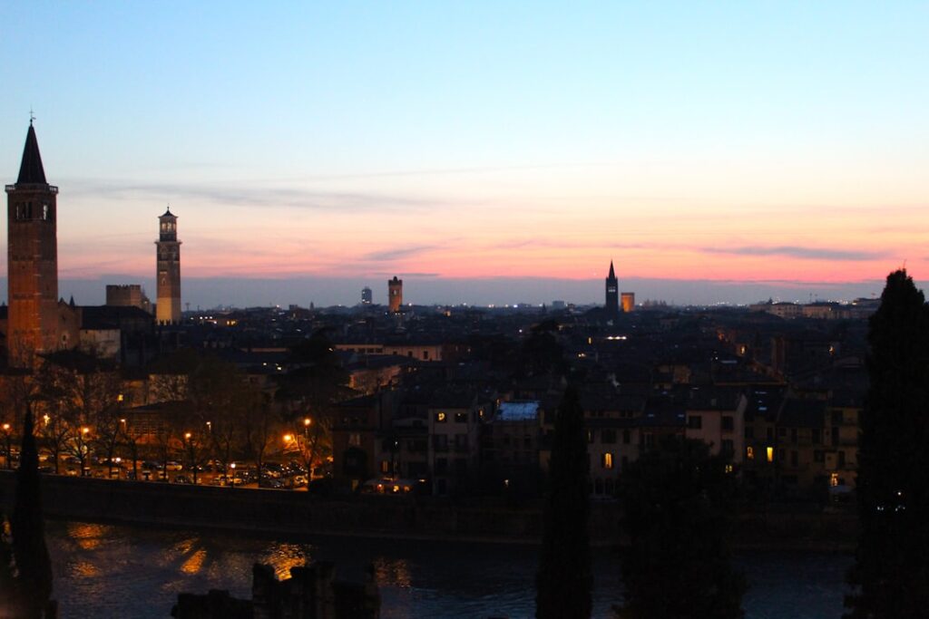 Skyline di Verona al crepuscolo con torri storiche e Adige