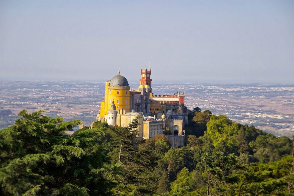 Vista mattutina nebbiosa del Palazzo da Pena con torrette gialle e rosse
