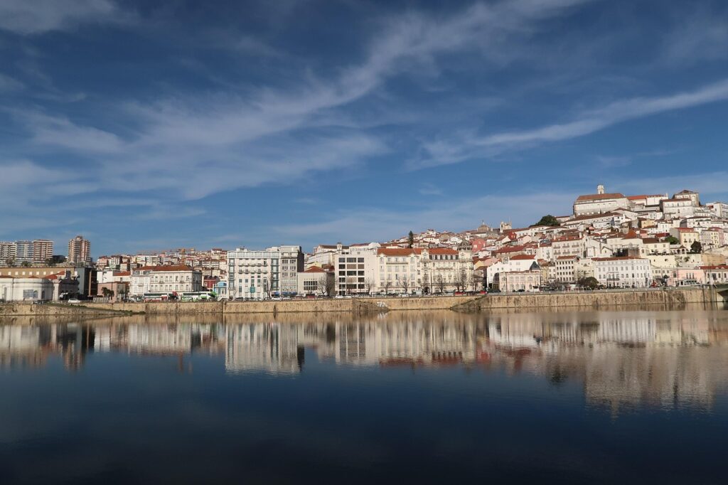 Sunset over the Mondego River and Coimbra's riverside walkway
