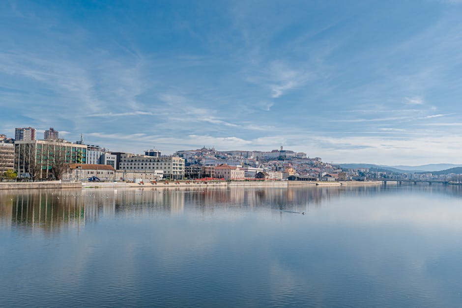 Skyline van Coimbra gezien vanaf de Mondego rivier bij zonsondergang