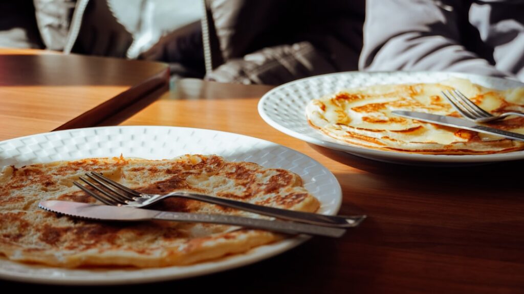 Crêpe restaurant interior with large sweet and savory crêpes on plates