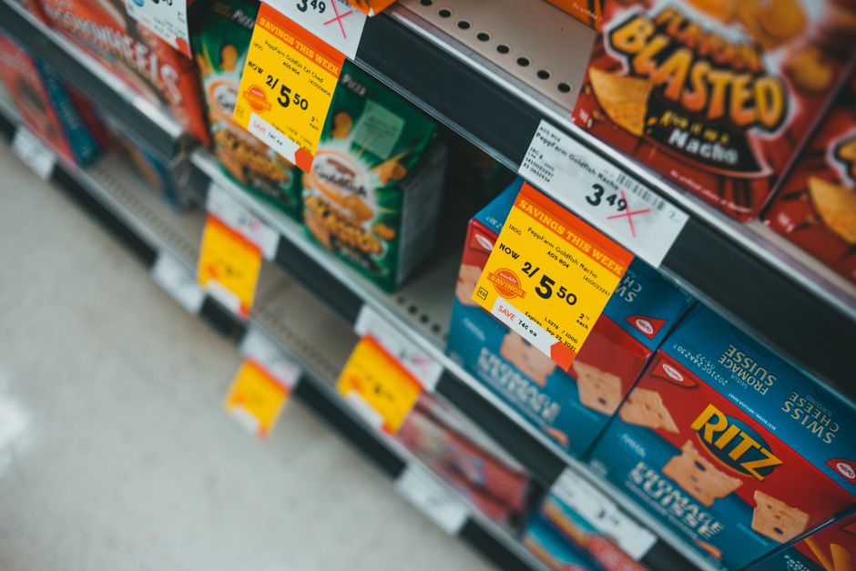 Scaffali discount con etichette prezzi su tofu e latte d'avena