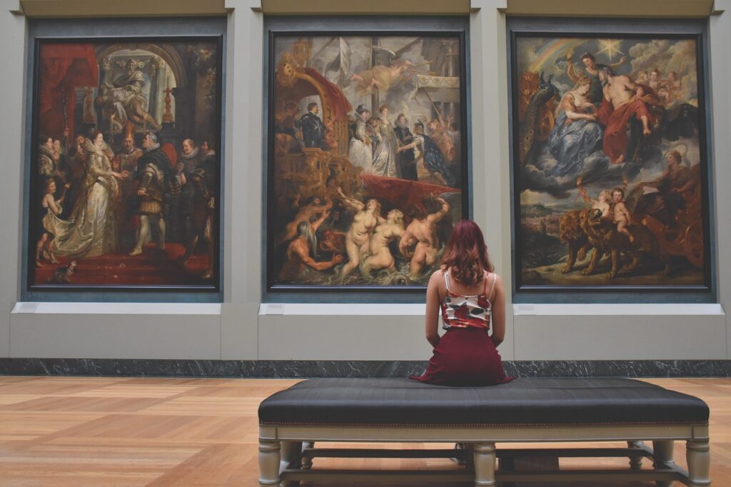 Museumsinnenraum mit Besuchern vor Gemälden