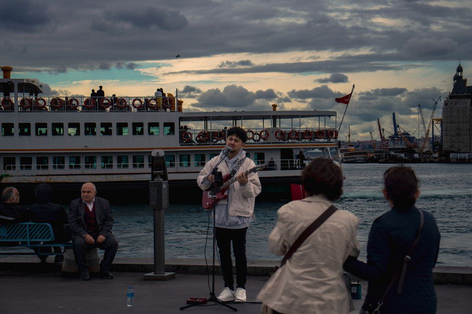 Straatmuzikant bij de kade, reflecties op het water van Genève