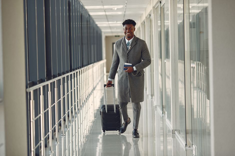 podróżny trzyma paszport idący przez terminal lotniska w Genewie