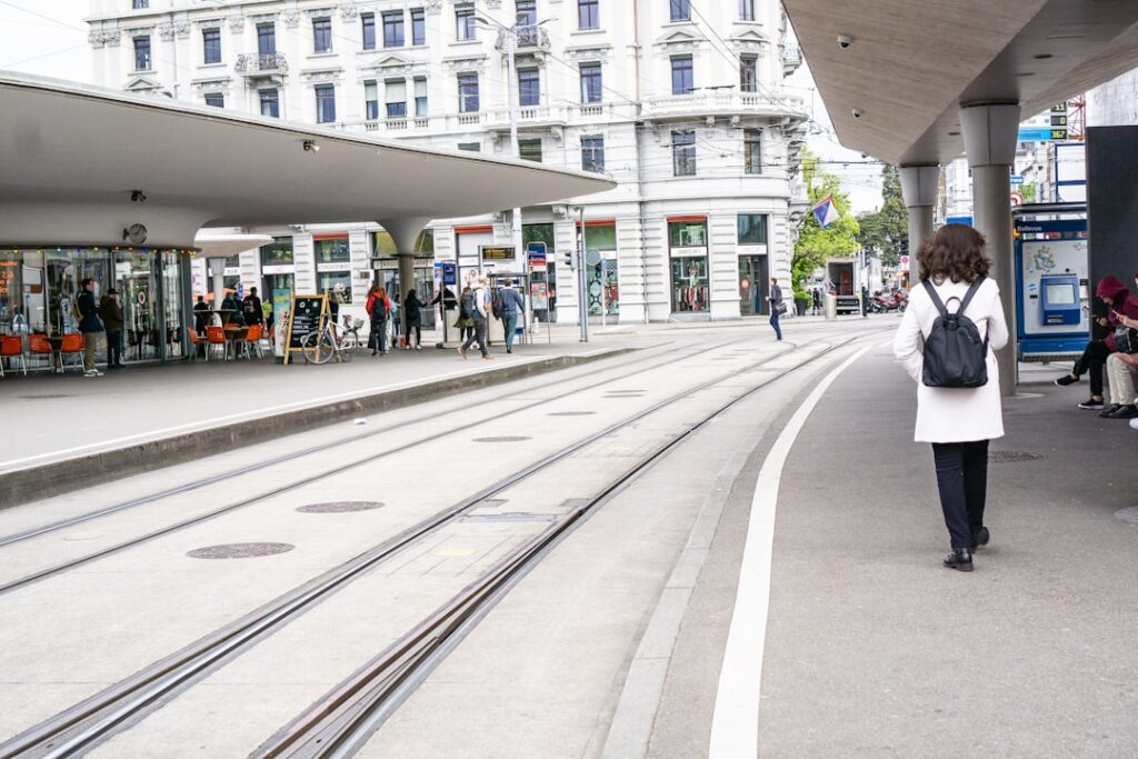 Reisender an Tramhaltestelle in Zürich schaut auf Karte in der Nähe eines Spitals