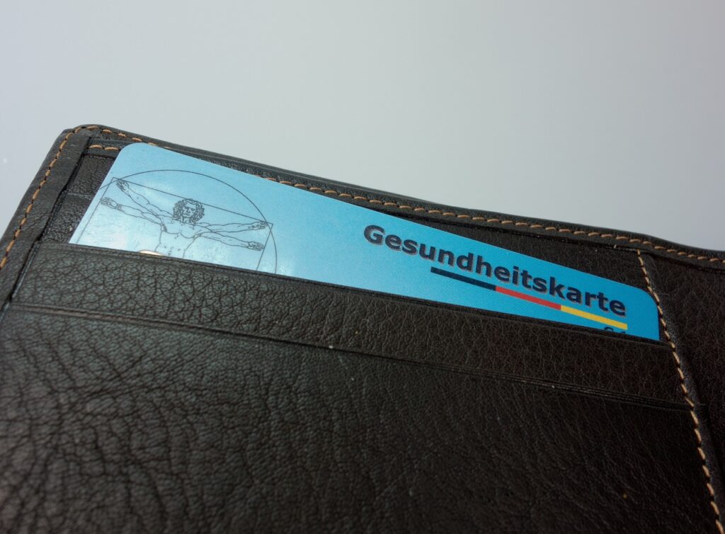 Reisender hält Europäische Krankenversicherungskarte an Spitalrezeption