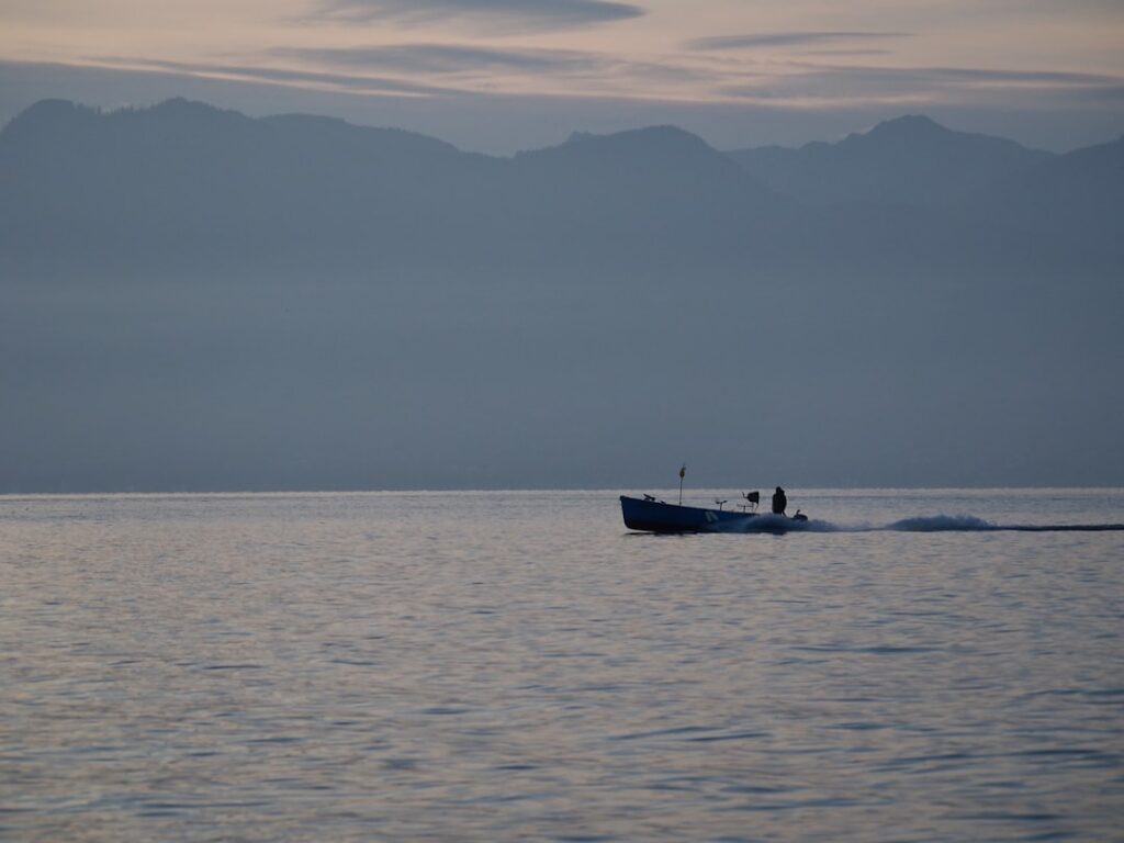 Lake Geneva at sunset with a small fishing boat near Lausanne