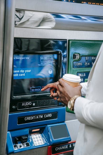 Bankomat wewnątrz banku z klientem wkładającym kartę